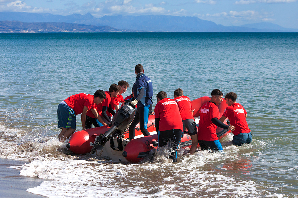 Alumnos de Grupo FASST botando una embarcación neumática de rescate en la playa
