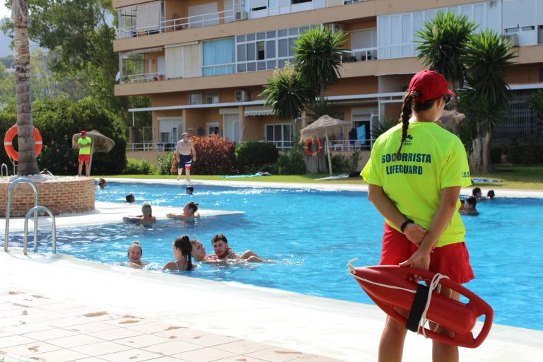 Socorrista de Grupo FASST con tubo de rescate vigilando una piscina